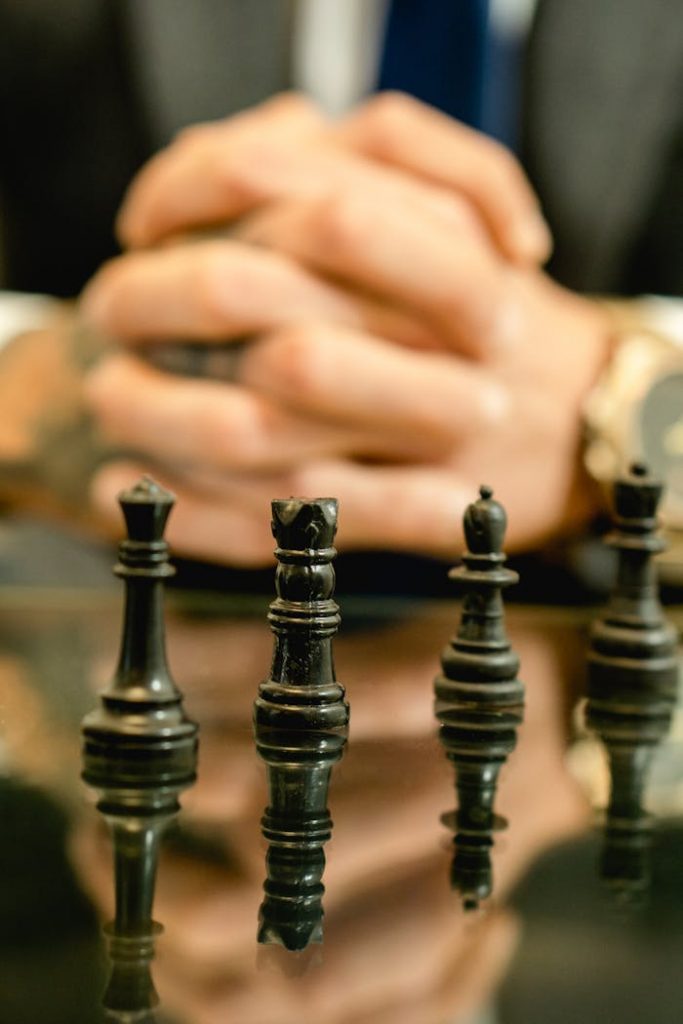 Chess pieces on glass table symbolize strategy and decision-making in business context.